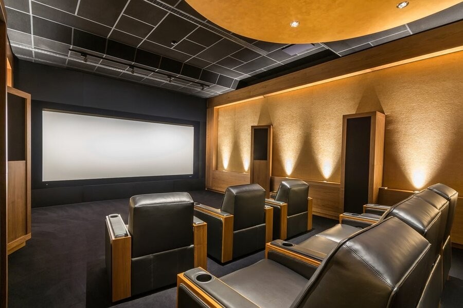 A custom home theater setting with comfy seats and a large screen.