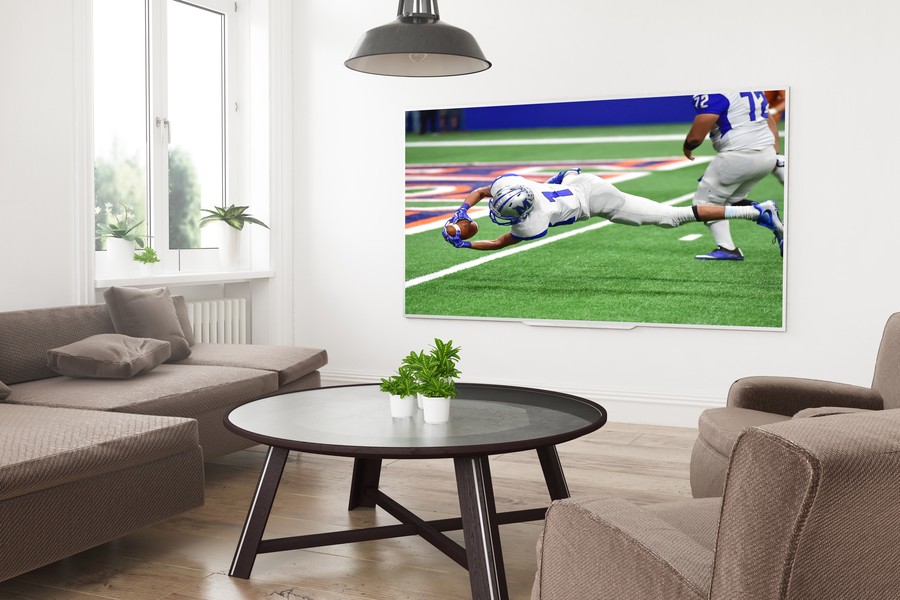 arge screen LED TV featuring football mounted on the wall.