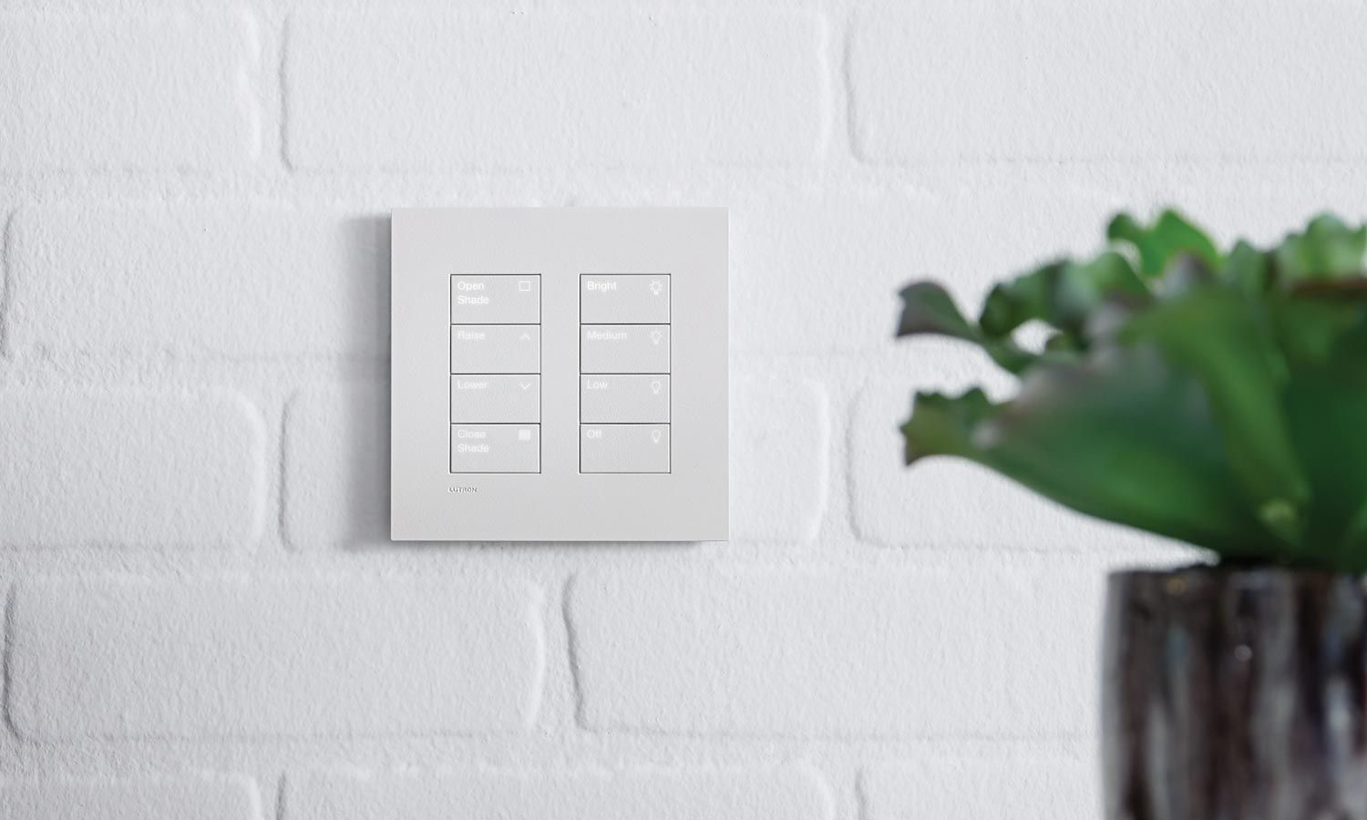 white keypad on white brick wall lutron