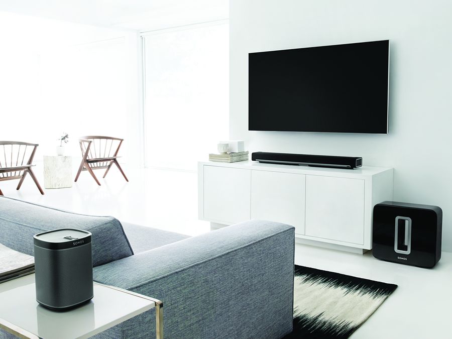 Sonos speakers and hub next to tv on white wall